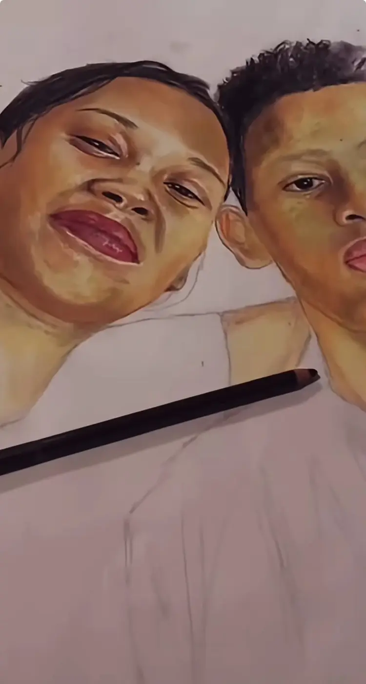 A double portrait in progress, with completed faces and a pencil resting on the drawing.