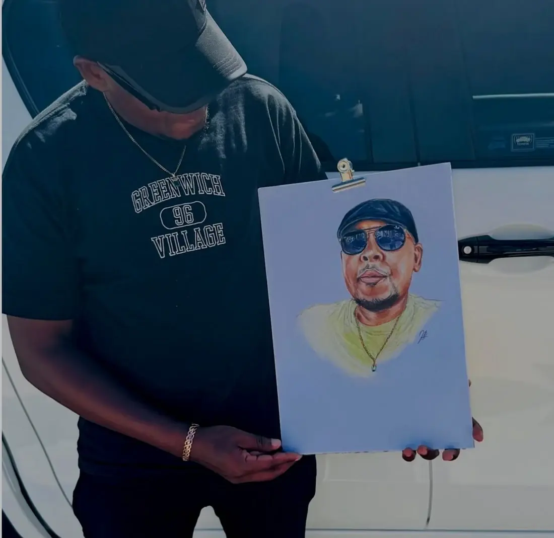 A person holding a completed coloured-pencil portrait outdoors.