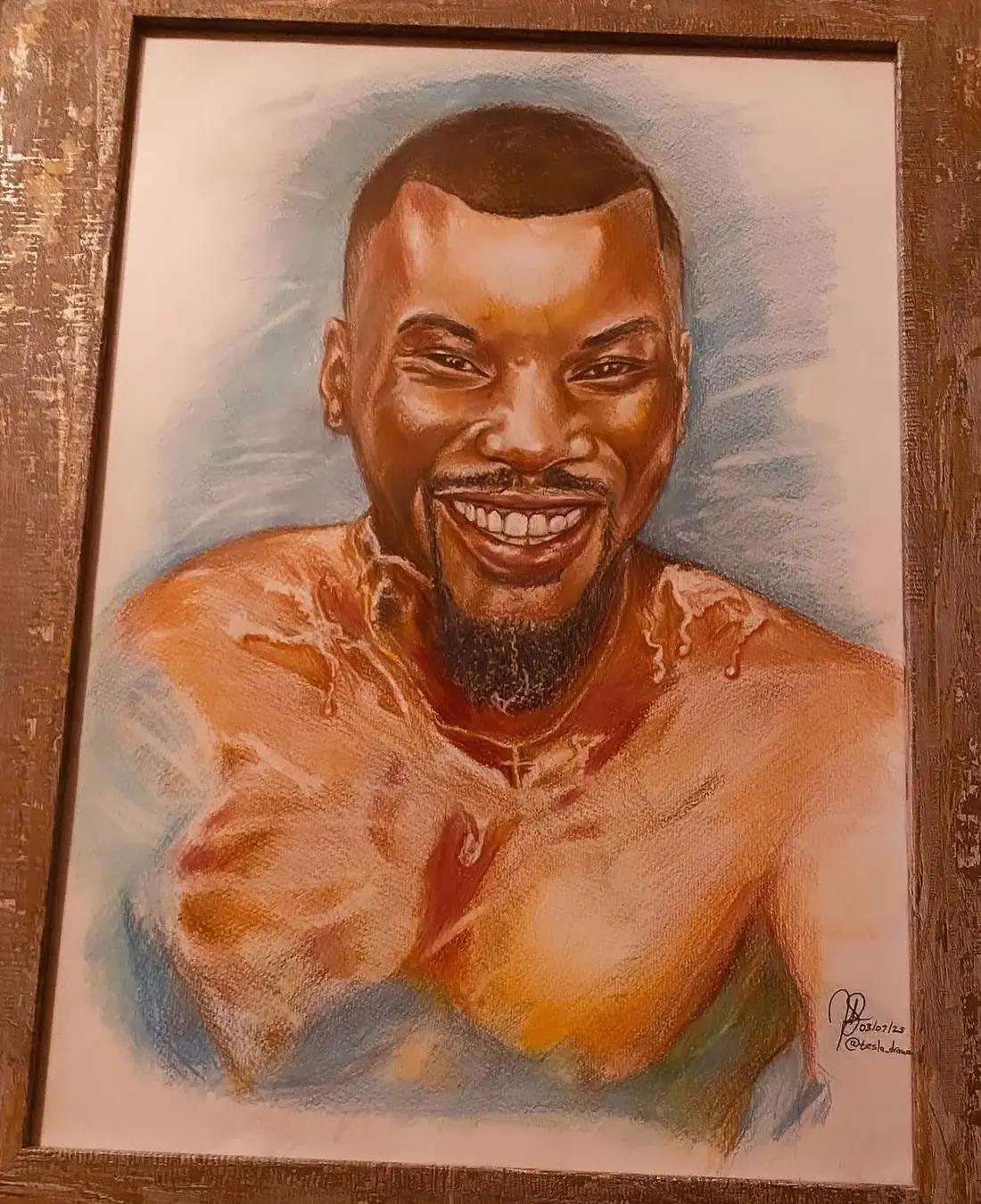 Framed coloured-pencil portrait of a smiling man against a blue background.