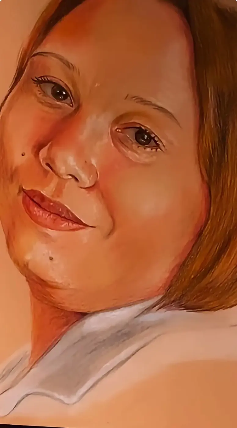 Close view of a coloured-pencil portrait with warm lighting and a pale collar.